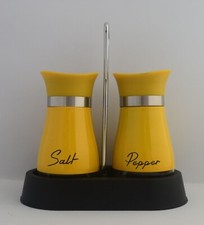 Yellow salt and pepper shakers with clear glass bottom in holder picture