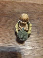 vintage small blonde baby sitting in a wheeled basket  picture