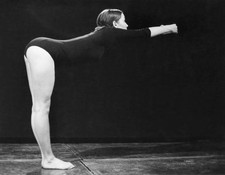 Young woman possibly a gymast dressed a leotard leans forward a st- Old Photo picture