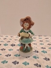 vintage porcelain or bisque figurine of a girl playing an accordion. picture