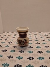 small, hand-painted ceramic vase with a floral design. picture