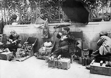 Shoe shiners with their shoe shine boxes on the street. One scratc- Old Photo picture